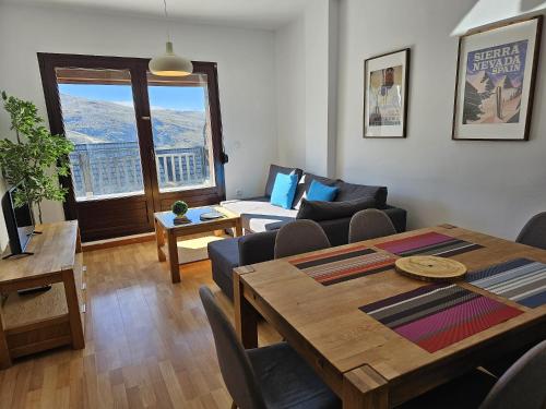 IMEDA Apartamento LOS ALPES I في سييرا نيفادا: غرفة معيشة مع طاولة وأريكة