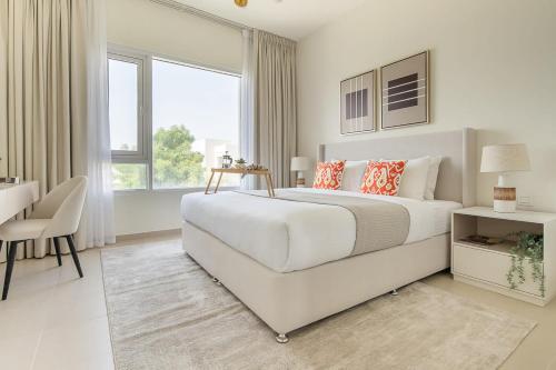 1 dormitorio blanco con 1 cama blanca grande y escritorio en Frank Porter - Urbana 3, en Dubái