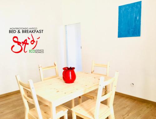 a wooden table with a red vase on top of it at B&b Sà Di.. in Monterotondo