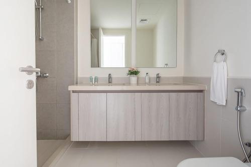 een badkamer met een wastafel en een spiegel bij Frank Porter - Urbana 3 in Dubai