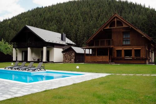 una casa con piscina y sillas frente a ella en Berghaus Bukovel en Bukovel