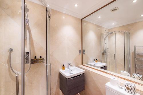 a bathroom with two sinks and a shower at The Courtfield - Serviced Apartments in London