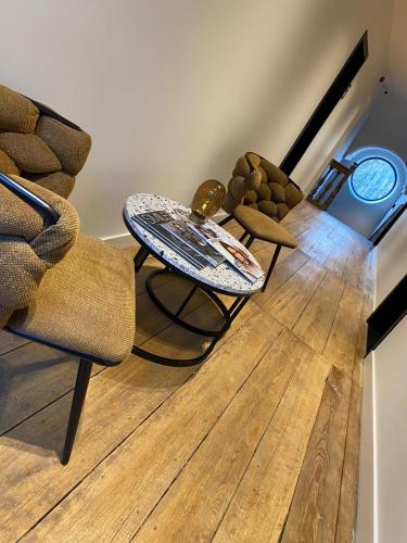 a living room with a table and chairs on a wooden floor at Hôtel Le Manoir in Marche-en-Famenne