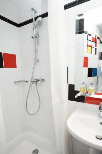 une salle de bain avec douche et lavabo dans l'établissement Hôtel Du Mont Dore Batignolles, à Paris