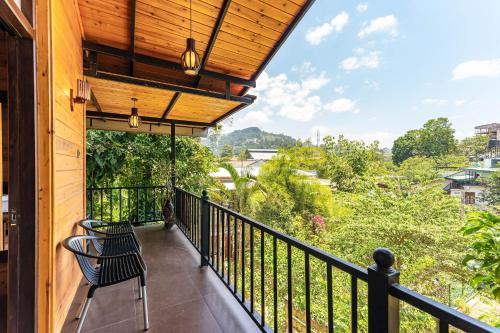 a balcony with a black railing and a chair at Maleesha Homestay in Ella
