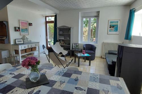 un salon avec un vase de fleurs sur une table dans l'établissement Charmante maison, 3 chambres, 10 min des plages, à Crach