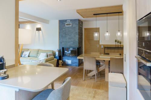 een keuken en een woonkamer met een witte tafel en stoelen bij Mammoth Lodge by Alpine Residences in Courchevel