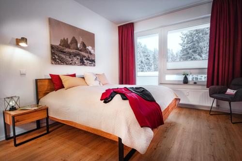 1 dormitorio con 1 cama grande y cortinas rojas en Bocksberg-Lodge, en Goslar
