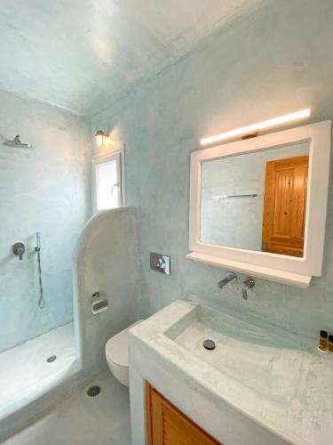 a bathroom with a sink and a toilet and a mirror at Villas Scirocco in Fira
