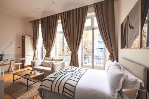 1 dormitorio con 1 cama, 1 silla y 1 ventana en The Courtfield - Serviced Apartments, en Londres