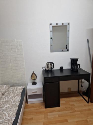 um quarto com uma secretária preta e um espelho em Appartamento centrale em Hanôver