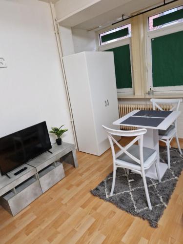 uma sala de estar com uma mesa e uma televisão e um quadro-negro em Appartamento centrale em Hanôver