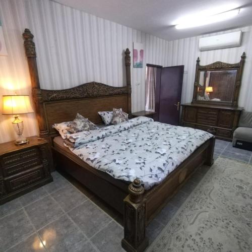 1 dormitorio con 1 cama grande y espejo en العين الهيلي مصباح ب 7 en Al Ain