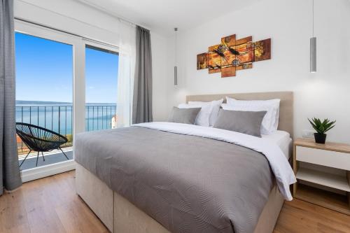 ein Schlafzimmer mit großem Bett und Balkon in der Unterkunft Villa Nonna Tonina in Podstrana