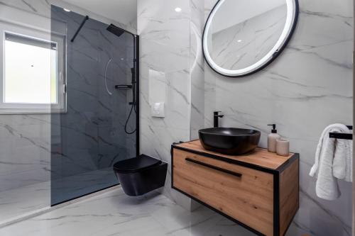 ein Badezimmer mit Waschbecken und Spiegel in der Unterkunft Villa Nonna Tonina in Podstrana