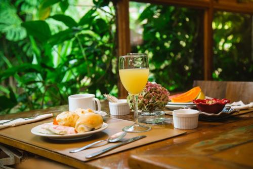 un tavolo con un bicchiere di succo d'arancia e cibo di Serra do Ibitipoca Hotel de Lazer a Conceição da Ibitipoca