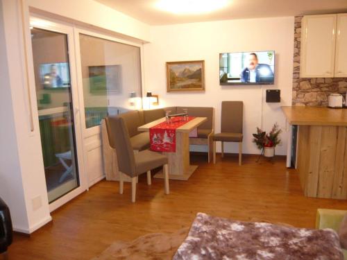 ein Wohnzimmer mit einem Tisch und Stühlen sowie einem TV in der Unterkunft Sport Alpin Wohnung 110 in Oberstdorf