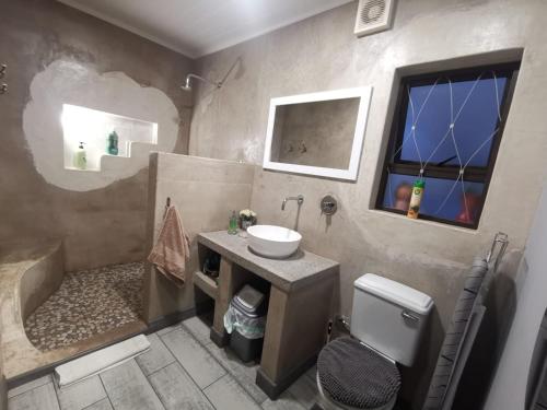 a bathroom with a sink and a tub and a toilet at Serendipity NO TV in Polokwane