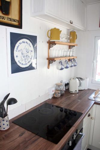 a kitchen with a stove top oven in a kitchen at The Little Beach House, Sennen Cove in Sennen