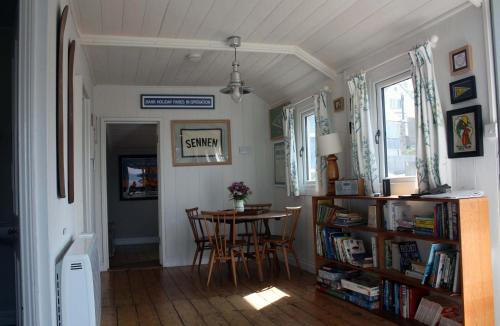 a dining room with a table and chairs in a room at The Little Beach House, Sennen Cove in Sennen