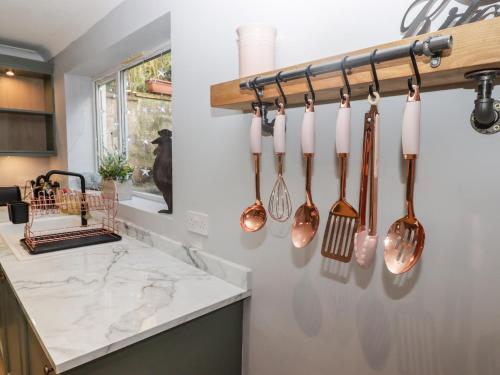 a kitchen with manyoons hanging on a wall at Golygfa Bryn in Porth