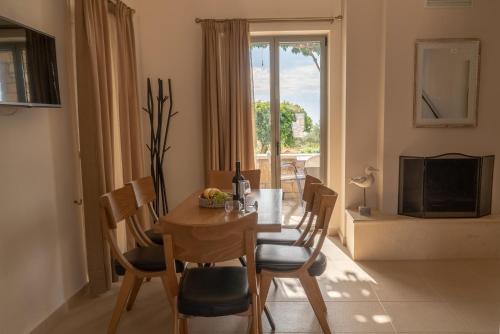 a dining room with a table and chairs and a window at Mythos Villas in Stoupa