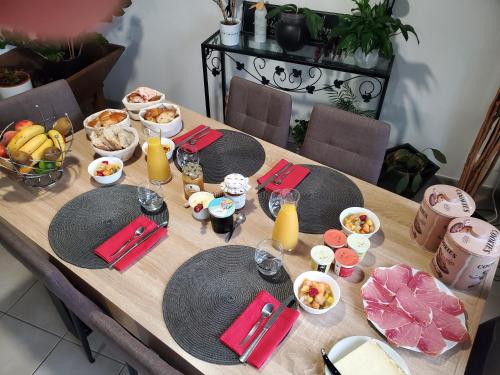a wooden table with plates of food and drinks on it at Chambres et Table d'hotes du calvaire in Villefranche-de-Rouergue