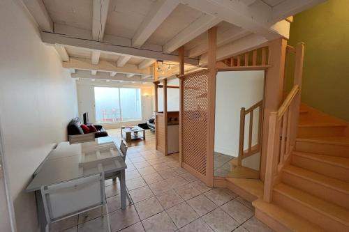 un salon avec une table et un escalier dans l'établissement Biarritz Beaurivage - Proche Cote des Basques, à Biarritz