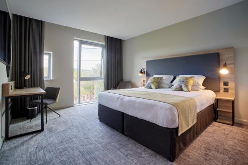 um quarto de hotel com uma cama grande e uma janela em Tŷ Newport em Newport