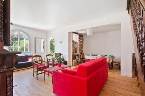 un salon avec un canapé rouge et une table dans l'établissement Bidart - Uhabia plage - Maison familiale, à Bidart