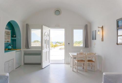 a kitchen and dining room with a table and a door at Villas Scirocco in Fira