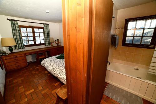 um quarto com uma cama e uma banheira ao lado de uma cama sidx sidx sidx em St-Gervais - Le Bettex - Montagnes em Saint-Gervais-les-Bains