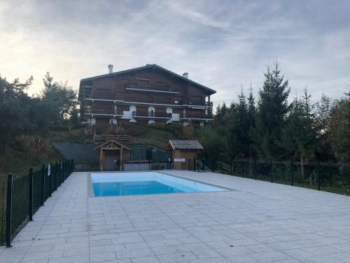 une maison avec piscine devant un immeuble dans l'établissement St-Gervais - Le Bettex - Montagnes, à Saint-Gervais-les-Bains