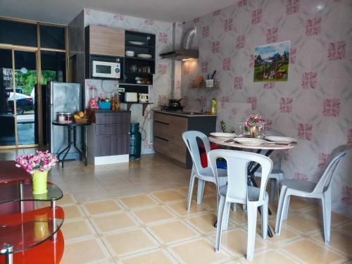 a kitchen with a table and chairs in a room at Kata Lina guesthouse in Kata Beach