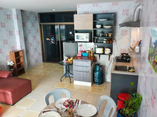 a kitchen and living room with a table and chairs at Kata Lina guesthouse in Kata Beach