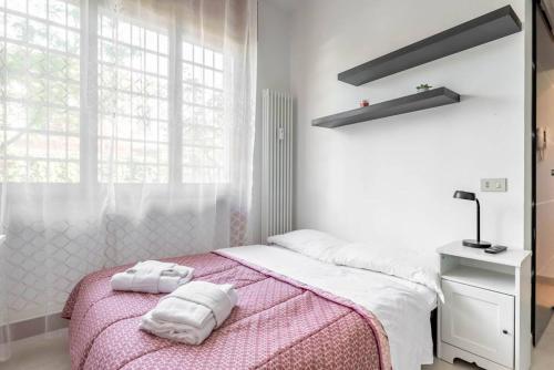 een witte slaapkamer met 2 handdoeken op een bed bij enJoy Home - Piccolo monolocale zona Ospedale in Padua