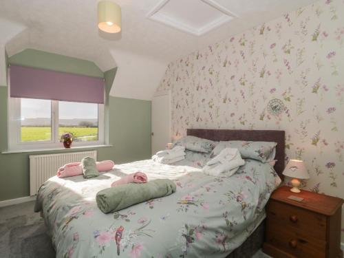 a bedroom with a bed with pink flowers on the wall at Coronation Cottages No 2 in Weston-super-Mare