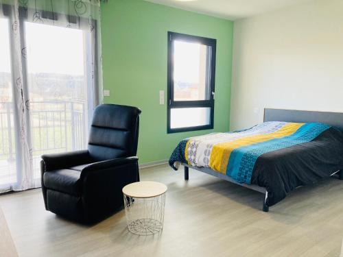 a bedroom with a bed and a chair and a chair at Résidence Services Séniors in Montignac
