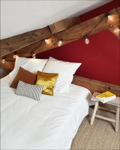 une chambre avec un lit blanc avec un mur rouge dans l'établissement Biarritz Beaurivage - Cote des Basques - Triplex, à Biarritz