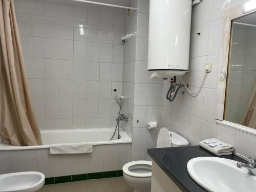 a bathroom with a sink and a toilet and a tub at Apartaments Crest Pas in Pas de la Casa