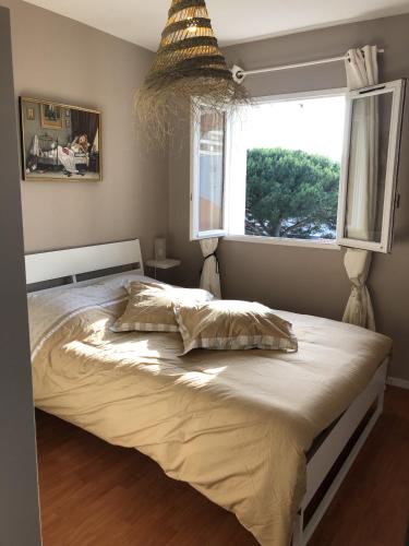 un grand lit dans une chambre avec une fenêtre dans l'établissement Biarritz - Petricot - Balcon - Calme, à Biarritz