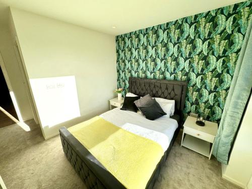 a bedroom with a bed and a green wall at East London Riverside in London