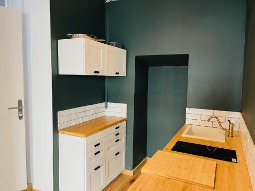 une petite cuisine avec un évier et un comptoir dans l'établissement Biarritz Beaurivage - Magnifique T1 bis, à Biarritz