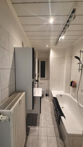 a white bathroom with a tub and a sink at Gasthaus Pavillon in Dresden