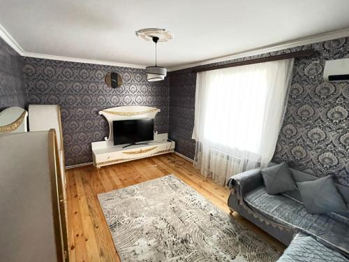 een woonkamer met een bank en een tv bij Resulzade Villa in Baku