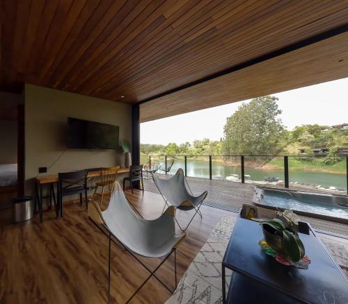 a living room with white chairs and a large window at Joinn Houtel in Guatapé