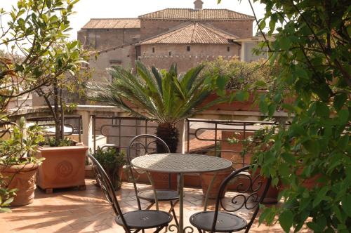 einen Tisch und Stühle auf einer Terrasse mit einem Gebäude in der Unterkunft Hotel Lancelot in Rom