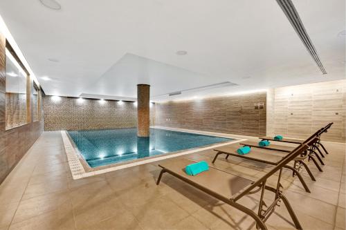 een zwembad in een kamer met een tafel en stoelen bij Hotel Do Caracol in Angra do Heroísmo