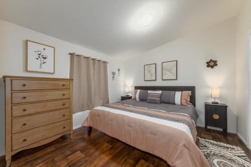 a bedroom with a bed and a dresser at Cute and Cozy 3 Bed 2 Bath Home in North Spokane in Spokane