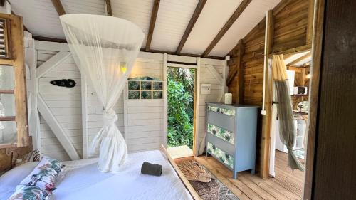 GourbeyreにあるChalet de Doléのベッドルーム(蚊帳付きのベッド付)